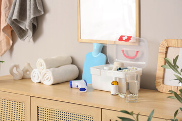 Home first aid kit with medical supplies on commode in bathroom