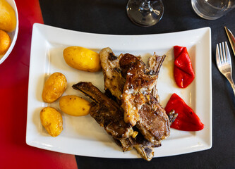Roasted lamb ribs aragonese, pepper and boiled potato served on plate