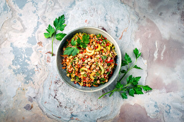 Traditional German wild rice salad with fresh chopped vegetables and onion served as top view in a...