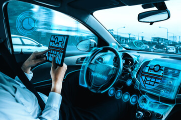 Self-driving autonomous car with relaxed young man sitting at driver seat is driving on busy highway road in the city. Concept of machine learning, artificial intelligence and augmented reality. uds