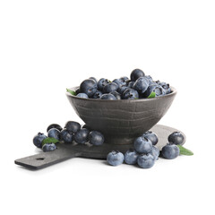 Black cutting board and bowl of ripe blueberry on white background, closeup