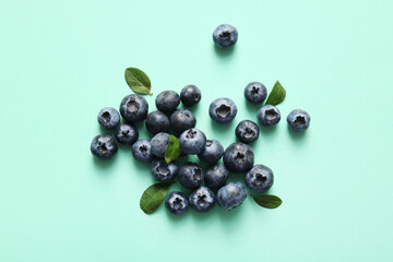 Heap of fresh ripe blueberry on turquoise background