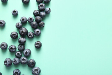 Many ripe blueberry on turquoise background