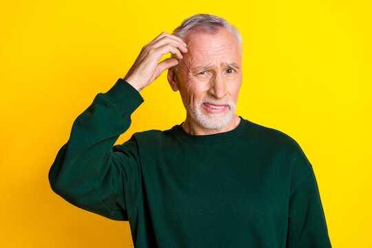 Photo portrait of lovely pensioner man confused scratch head dressed stylish green garment isolated on yellow color background