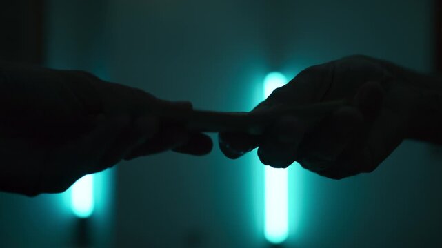 Silhouette of Hands Exchanging Money for Illegal Substances
