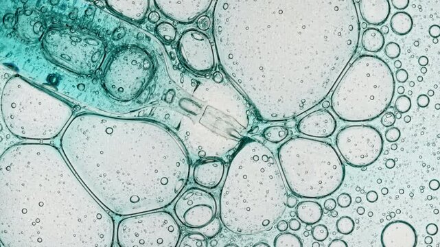 Transparent cosmetic blue gel fluid with molecule bubbles oil spreading on a white background. Macro Shot of Natural Organic Cosmetics, Medicine. Production Close-up. Slow Motion. . High quality 4k 