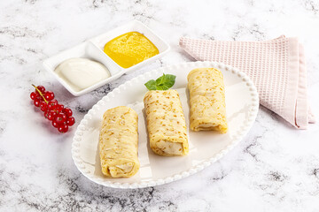 Homemade stuffed pancakes with honey and cream sour