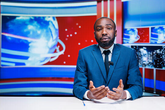 News anchor man reading media papers, transmitting live information from exclusive sources to create latest news report. African american journalist presenting daily events and important topics.