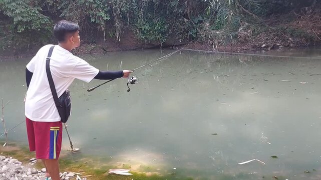 a man who was doing his fishing hobby using casting techniques in a river in the Magelang area, Central Java, Indonesia
