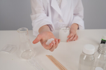 Faceless girl doing chemical experiments on a white background.