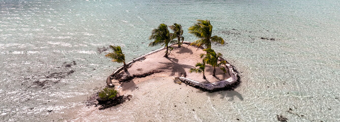 Panoramic view of a tiny motu tropical island in the shape of a romantic heart. 