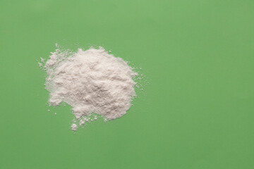 Baking soda powder on green background - Healthy food
