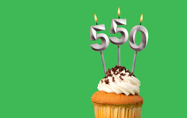 Birthday with number 550 candle and cupcake - Anniversary card on green color background