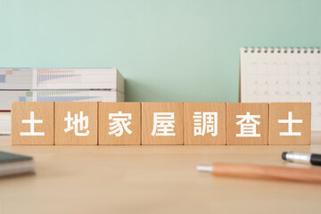 土地家屋調査士の文字が入ったブロックが置かれたデスク