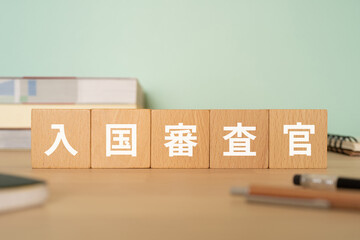 入国審査官の文字が入ったブロックが置かれたデスク