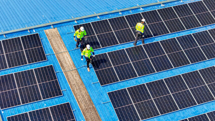 engineer man inspects construction of solar cell panel or photovoltaic cell by electronic device. Industrial Renewable energy of green power. factory worker working on tower roof.