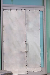 Blank empty white paper poster taped to metal door outside store windows