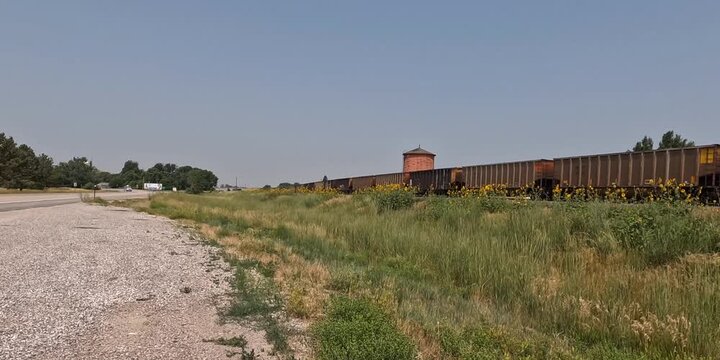 Coal train goes by the historical wooden water tower east of Lusk, Wyoming.cks