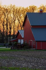A red barn on a farm at sunset