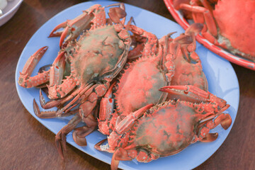 Steamed crabs eat with spicy dipping sauce in the restaurant. Seafood background. Asia food.