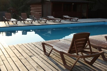Outdoor swimming pool with clear water, sunbeds and house