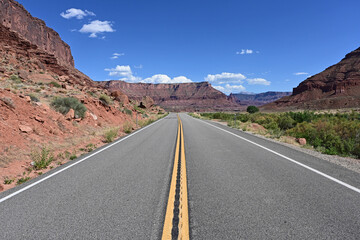 Red rock landscape along Utah State Route 128 near Moab on sunny summer afternoon.
