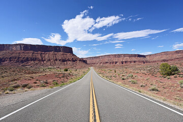 Red rock landscape along Utah State Route 128 near Moab on sunny summer afternoon.