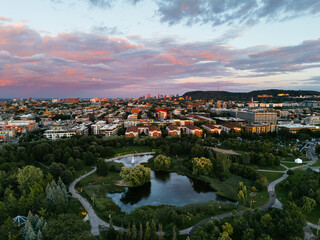 Drone view of the colorful sunset and park, downtown, and Royal Mountain in the background....