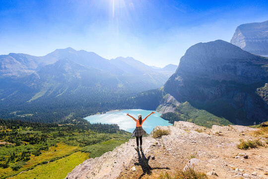 A woman looks at a mountain and lake view in Glacier National Park