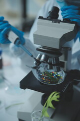 Scientist cutting plant tissue culture in petri dish, performing laboratory experiments. Small...