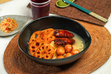 lotus root Cart Noodles pot with drink and chopsticks served in pot isolated on napkin side view of japanese food
