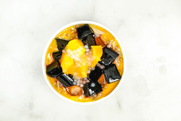 mango sago grass Jelly Yangzhi Manna Aiyu Jelly served in bowl isolated on grey background top view of asian food