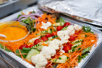 Chef salad in a silver catering container delivered for an event