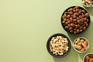 Various nuts in white and black bowls