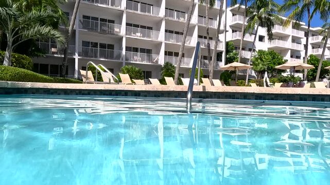Camera approaches cement steps and handrail in Florida resort pool