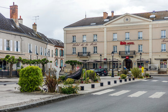 A charming view of the town square in Montargis, France, featuring the historic Hotel de la Poste and the modern ibis hotel, blending old-world charm with contemporary comfort