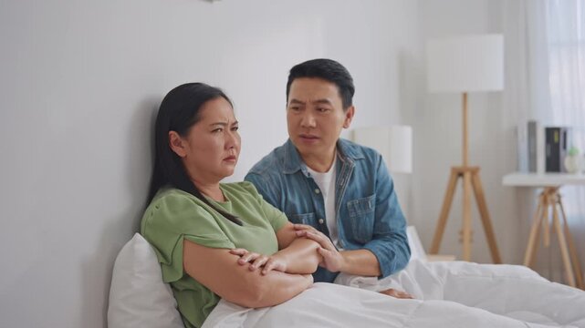 Asian guilty husband apologize and comforting his wife after argument. 