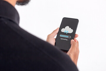 Man using a smartphone to upload data to cloud storage. Phone data backup and cloud data storage concept.