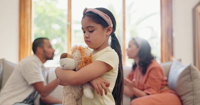 Sad, child and parents in a fight and teddy bear for comfort, support or care in divorce argument. Depressed, kid and hearing angry mom and dad fighting in living room with trauma, fear or anxiety