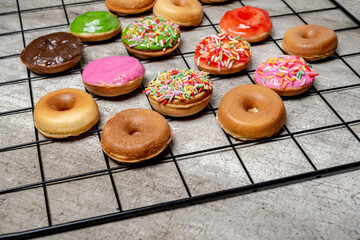 A tray of assorted mini donuts with sprinkles and frosting