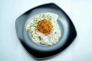 A black plate with a sunny side up egg on it
