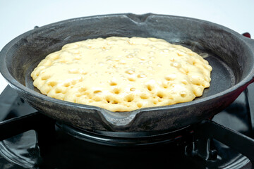 A pan of batter is cooking on a stove
