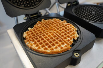 Belgian waffles in a frying pan on a kitchen table.