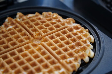 Belgian waffles in a frying pan on a kitchen table.