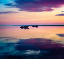 Fantastic summer seascape of Baltic sea with two motorboats. Colorful sky reflected in the calm...