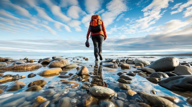 Woman exploring tide pools on a rocky beach, curious and adventurous.