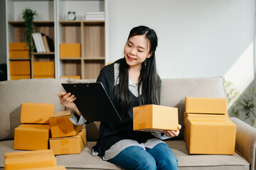 Young businesswoman managing online sales and shipping from a modern home office.