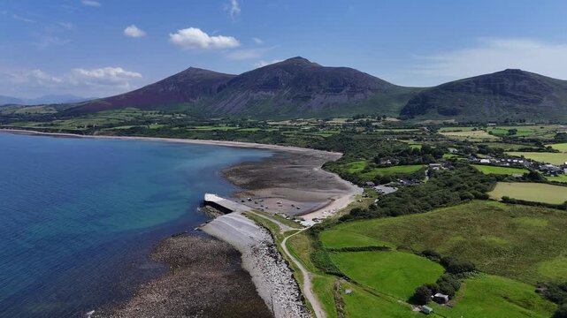 Trefor Beach, North Wales, Gyrn Goch and Gyrn Ddu mountains, harbor, clear waters and green fields