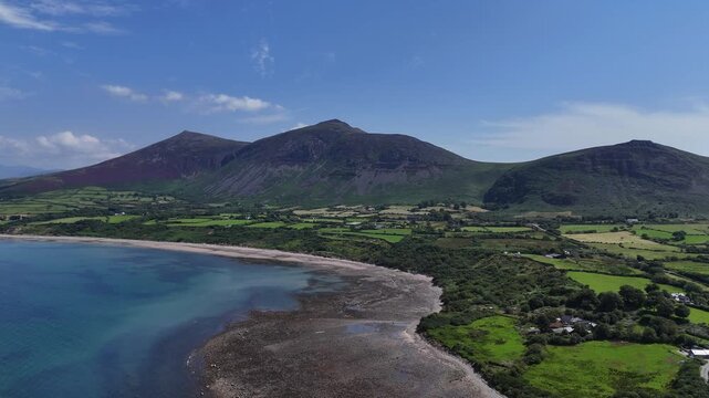Trefor Beach, North Wales, Gyrn Goch and Gyrn Ddu mountains, harbor, clear waters and green fields