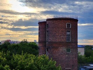 Two old abandoned brick towers on the outskirts of the city.